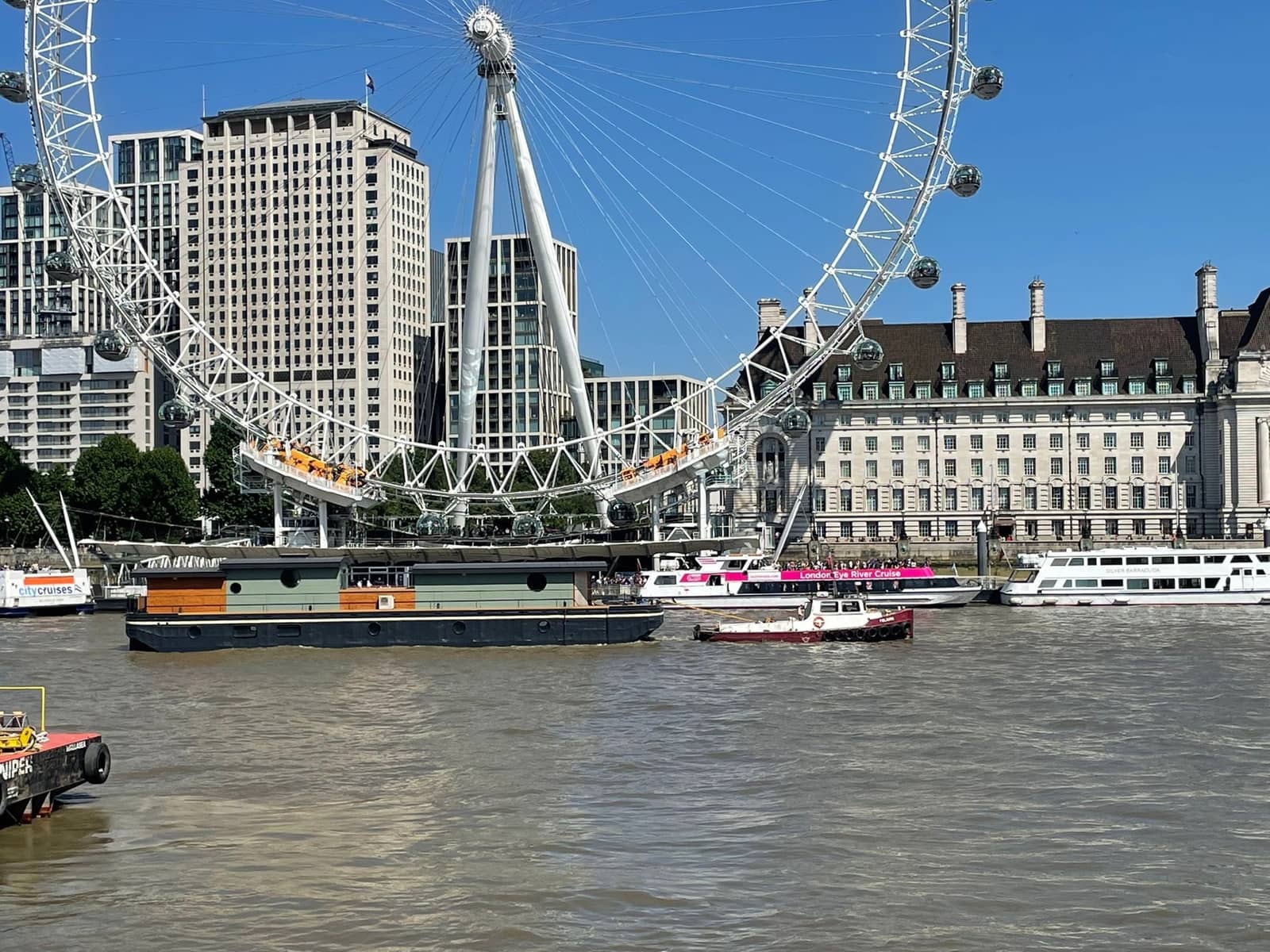 Tug and barge passing the London Eye